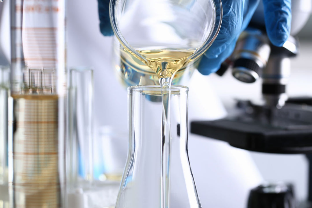 Scientist pouring liquid sample into flask for laboratory analysis, scientific research concept.